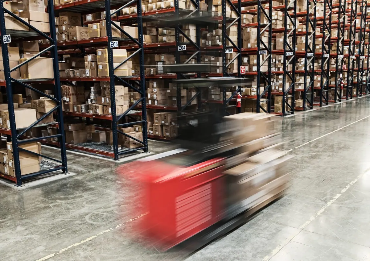 A lift truck speeding down a racked aisle